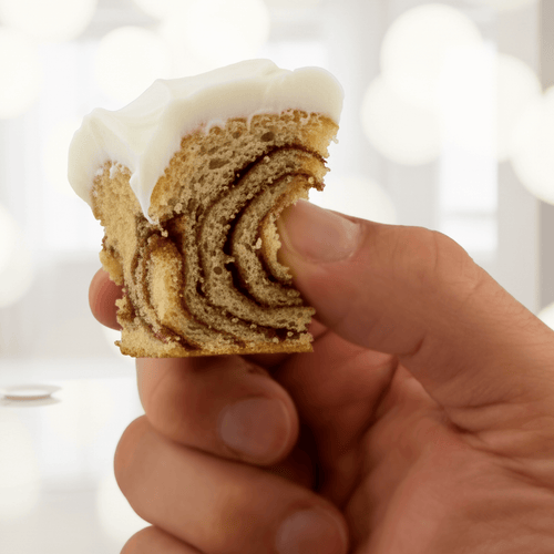 Cinnamon Roll protein cake held in hand, showcasing its swirly goodness and healthy dessert appeal.