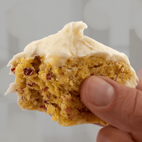 Close-up of a moist cranberry orange protein cake with creamy frosting, made from BAK Goods limited edition holiday mix.