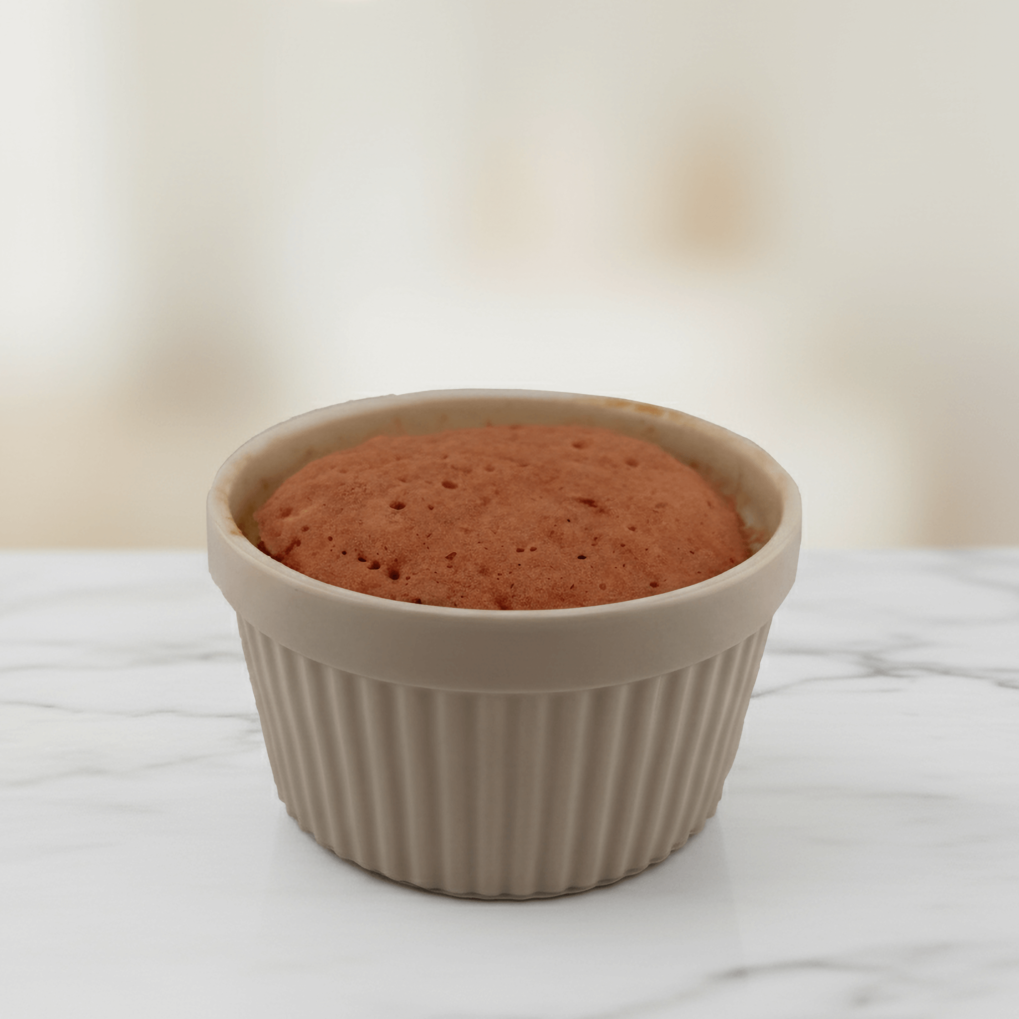 Strawberry Protein Cake Mix baked in a beige ramekin, showcasing a light and airy texture.
